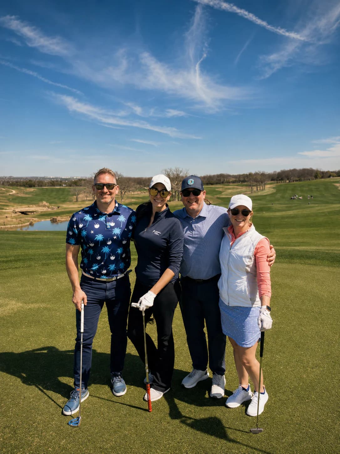 Four golfers standing together on a hilltop fairway